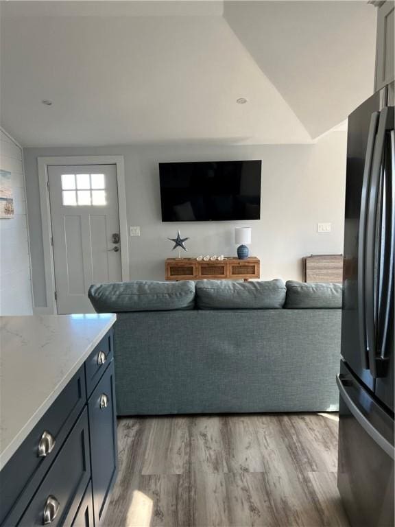 living room featuring light wood finished floors and vaulted ceiling