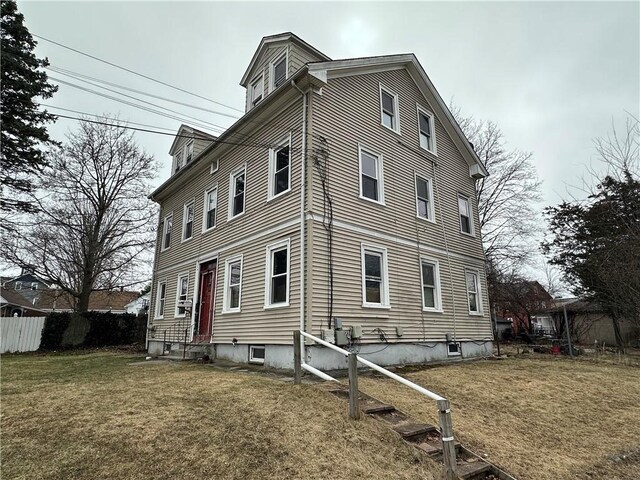 view of property exterior featuring a yard, central AC, fence, and entry steps