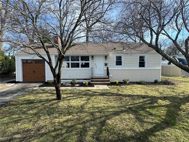 ranch-style home featuring fence, entry steps, a garage, a front lawn, and driveway
