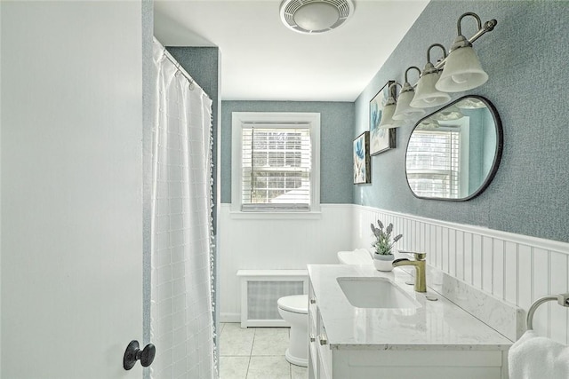 full bathroom featuring a wainscoted wall, tile patterned floors, visible vents, and toilet