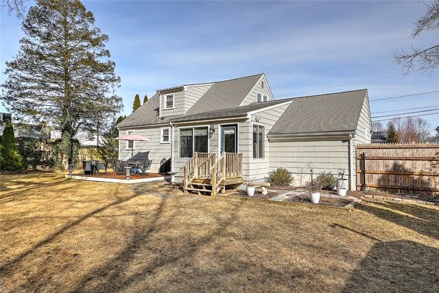 back of house with a patio, a shingled roof, fence, and a yard