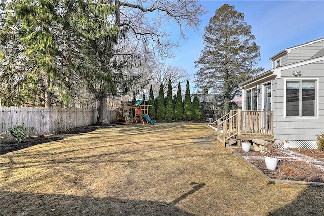 view of yard with fence and a playground