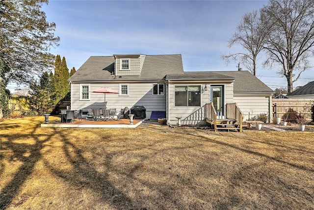 rear view of house with fence and a yard