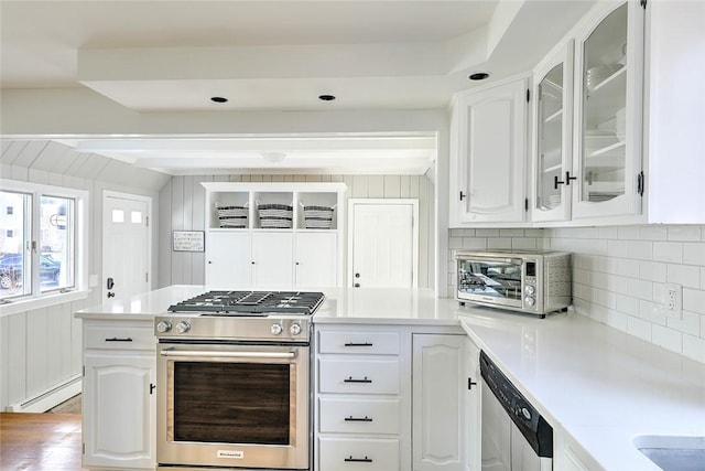 kitchen with light countertops, appliances with stainless steel finishes, glass insert cabinets, and baseboard heating