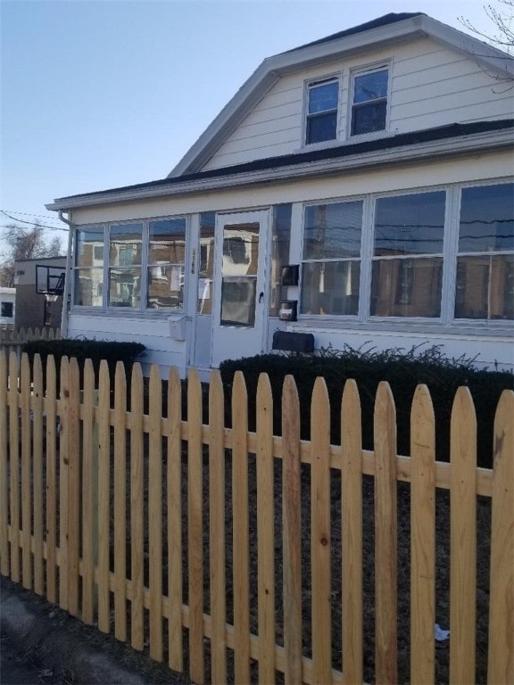 view of front of house with fence private yard and a sunroom