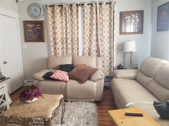 living area featuring a baseboard heating unit and wood finished floors