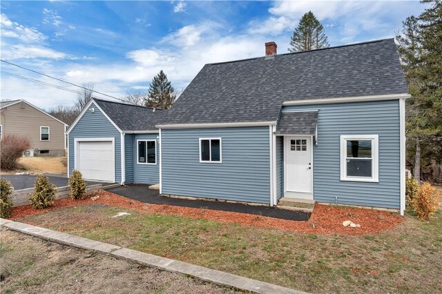 view of front of home with a chimney, a shingled roof, and aphalt driveway