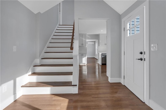 entrance foyer with baseboards, dark wood-style flooring, vaulted ceiling, and stairs