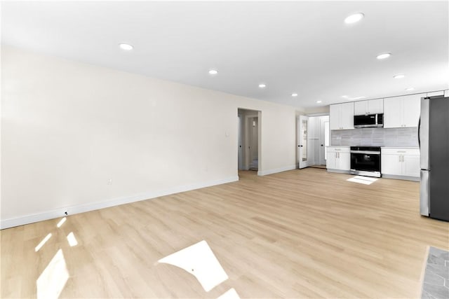 unfurnished living room featuring baseboards, light wood-style flooring, and recessed lighting