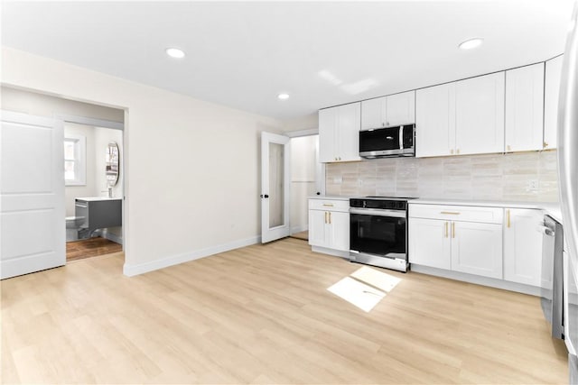 kitchen with light countertops, backsplash, light wood-type flooring, range with electric stovetop, and stainless steel microwave