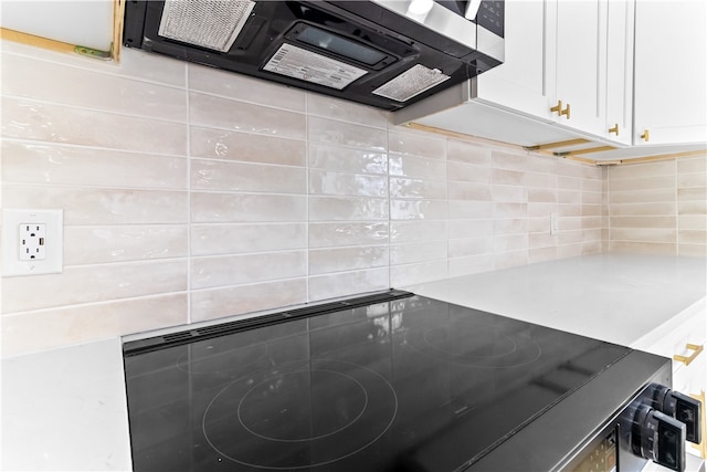 kitchen with light countertops, white cabinets, cooktop, and ventilation hood