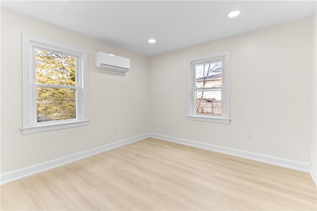spare room featuring baseboards, a wall mounted air conditioner, and recessed lighting
