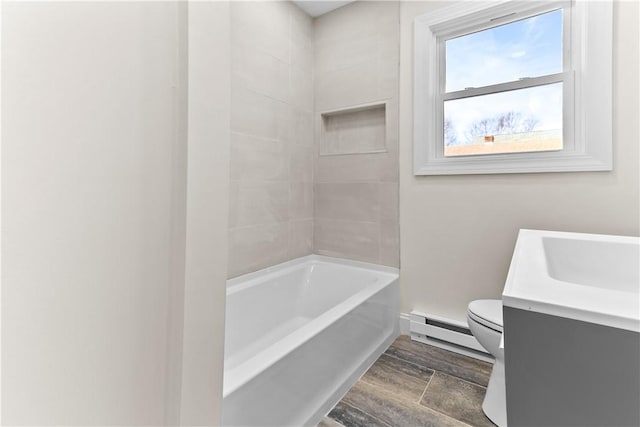 bathroom with baseboards, toilet, wood finish floors, vanity, and baseboard heating