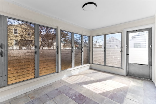 unfurnished sunroom featuring stone tile floors