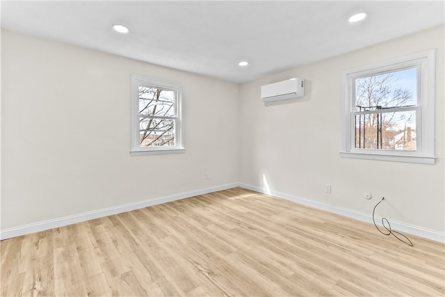 empty room featuring plenty of natural light, baseboards, a wall mounted air conditioner, and recessed lighting