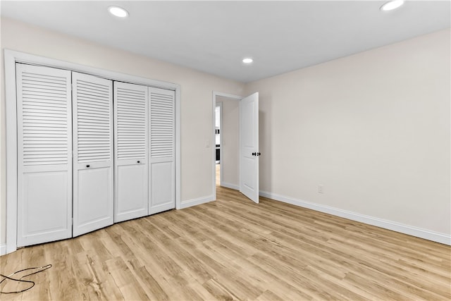 unfurnished bedroom featuring a closet, baseboards, recessed lighting, and light wood finished floors