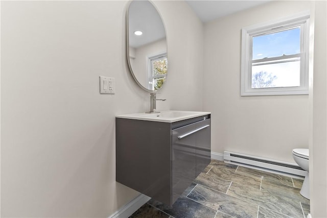 bathroom with baseboards, baseboard heating, toilet, and vanity