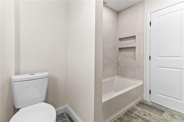 full bathroom with baseboards, wood tiled floor, toilet, and shower / bath combination