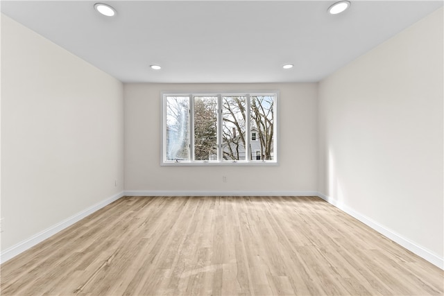 unfurnished room featuring baseboards, wood finished floors, and recessed lighting
