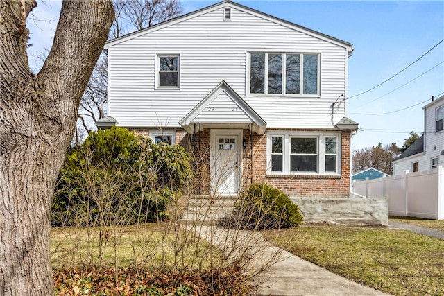 view of front of home with brick siding and fence