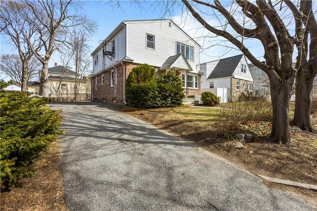 view of side of property featuring brick siding and driveway