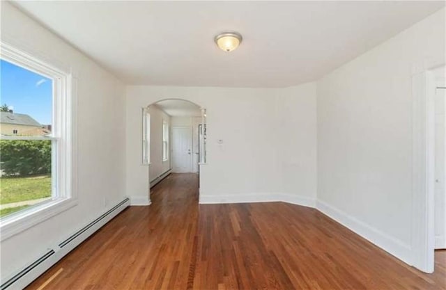 57 School St, East Providence, RI 02914 - spare room featuring plenty of natural light, baseboard heating, wood finished floors, and arched walkways