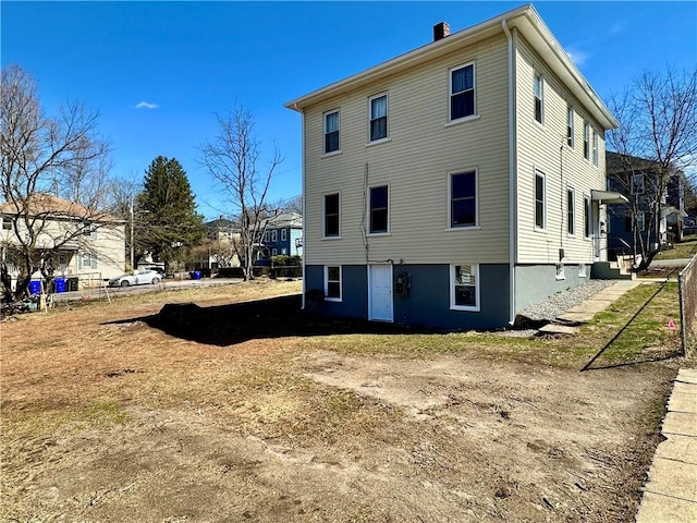 back of house featuring a chimney