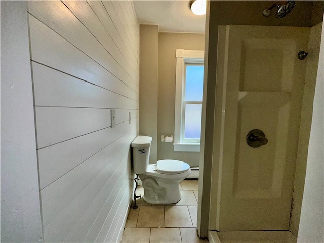 full bathroom featuring tile patterned floors, baseboard heating, toilet, and a shower stall