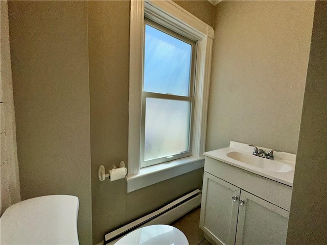half bathroom with a wealth of natural light, toilet, a baseboard heating unit, and vanity