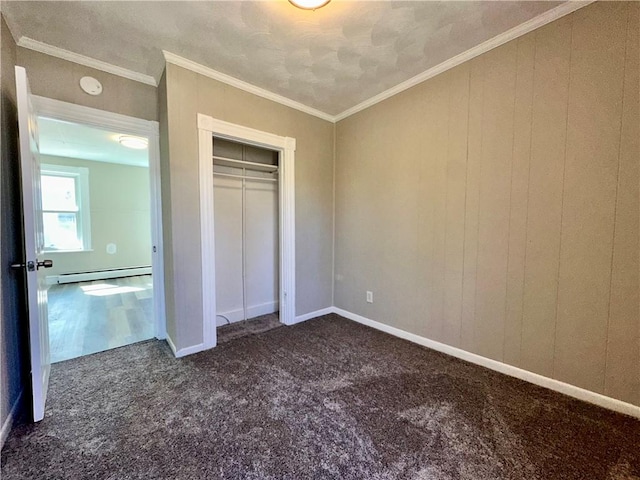 unfurnished bedroom with baseboards, dark colored carpet, a baseboard heating unit, and ornamental molding