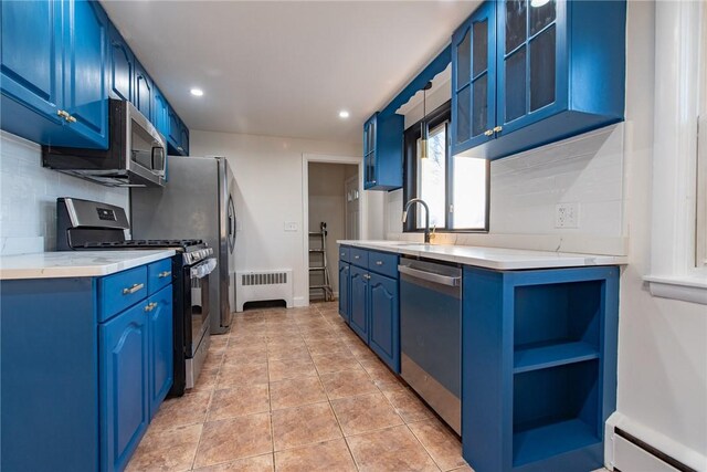 kitchen with tasteful backsplash, radiator heating unit, blue cabinets, appliances with stainless steel finishes, and baseboard heating
