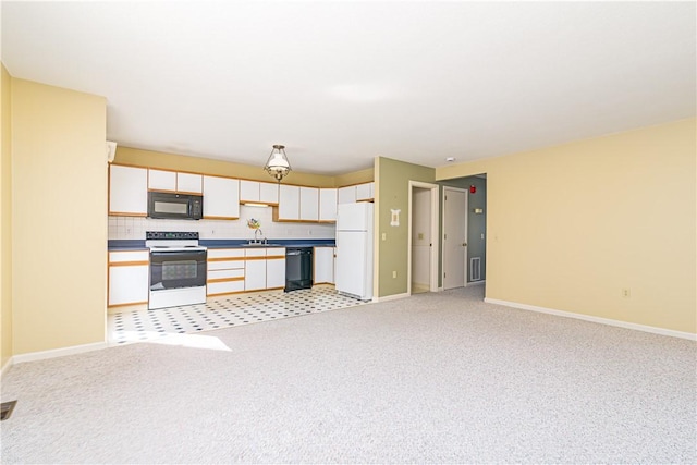 60 Margin St Unit 104, Westerly, RI 02891 - kitchen featuring black appliances, light carpet, open floor plan, and white cabinetry