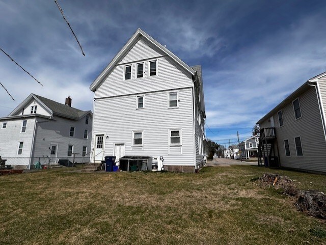 back of property featuring a lawn