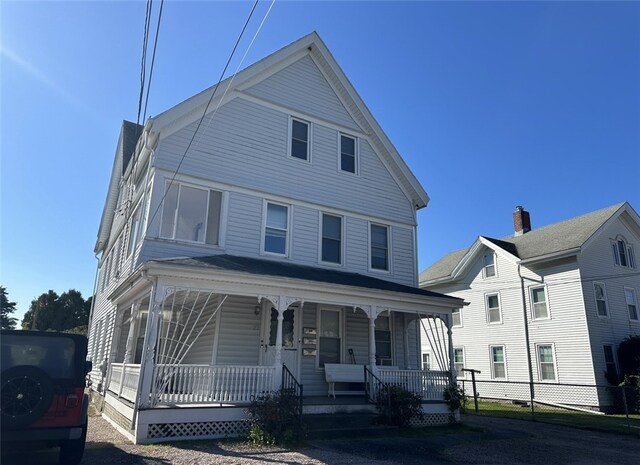 view of front of property featuring covered porch and fence