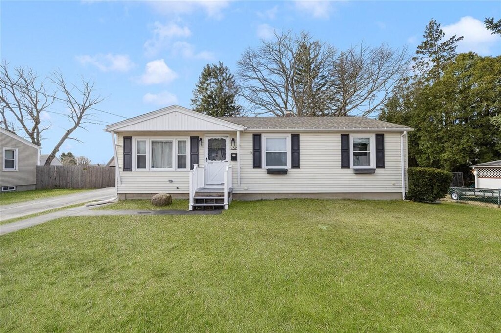 view of front of home with fence and a front lawn