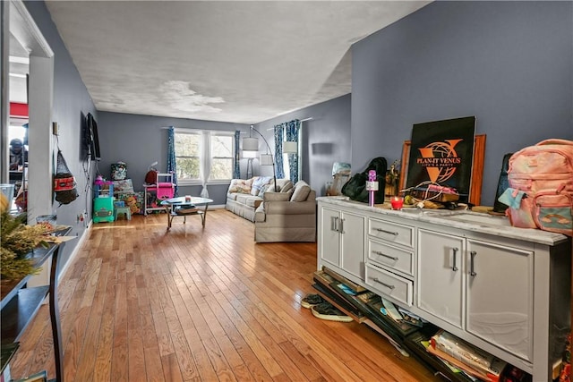 living area with baseboards and light wood-type flooring