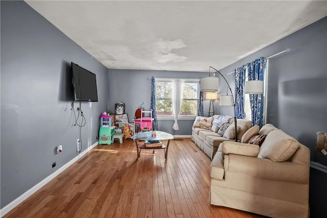 living area with baseboards and wood-type flooring