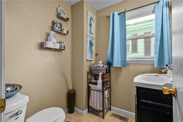 bathroom featuring toilet, vanity, tile patterned flooring, baseboards, and visible vents