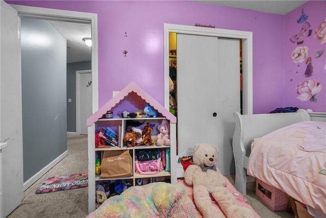 carpeted bedroom featuring baseboards and a closet