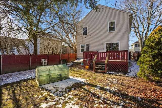 rear view of house with fence and a deck
