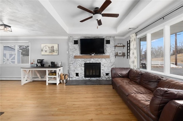 living room with a ceiling fan, light wood-style flooring, a healthy amount of sunlight, and a fireplace