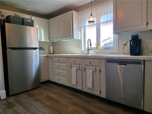 kitchen with light countertops, a sink, white cabinetry, dark wood-style floors, and stainless steel appliances