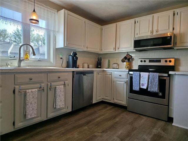 kitchen featuring dark wood-style flooring, light countertops, appliances with stainless steel finishes, white cabinetry, and a sink