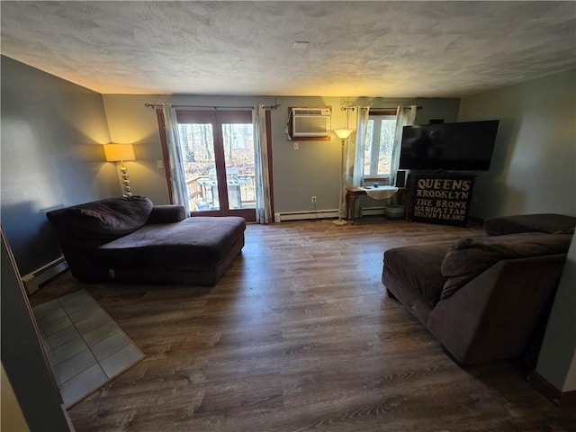 living room featuring baseboard heating, wood finished floors, an AC wall unit, and a textured ceiling