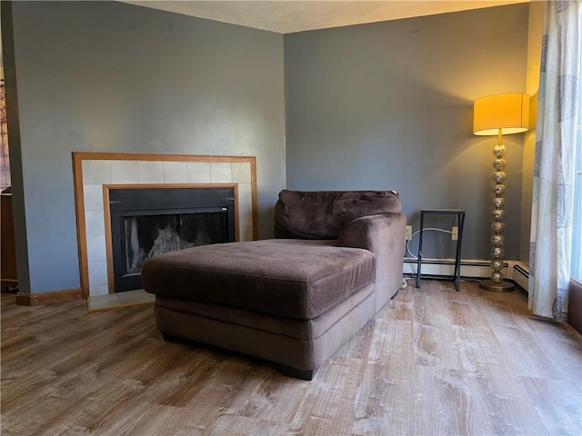 sitting room with a baseboard radiator, a fireplace, and wood finished floors