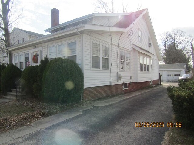 view of property exterior featuring an outdoor structure and a chimney