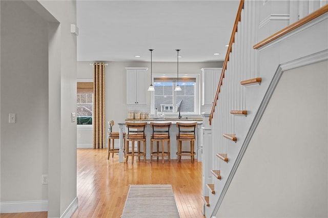 interior space featuring baseboards, stairs, recessed lighting, and light wood-style floors