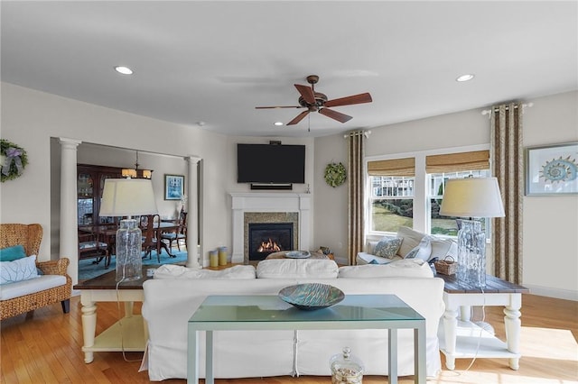 living area with ceiling fan, wood finished floors, a glass covered fireplace, and recessed lighting