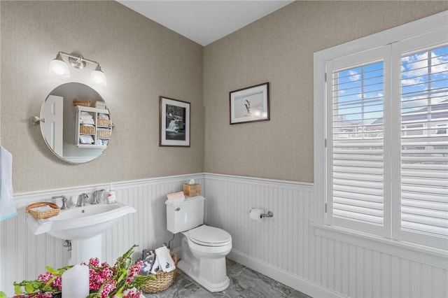 half bath with wainscoting and toilet