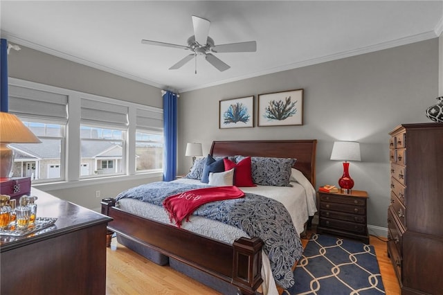 bedroom featuring crown molding, wood finished floors, and ceiling fan